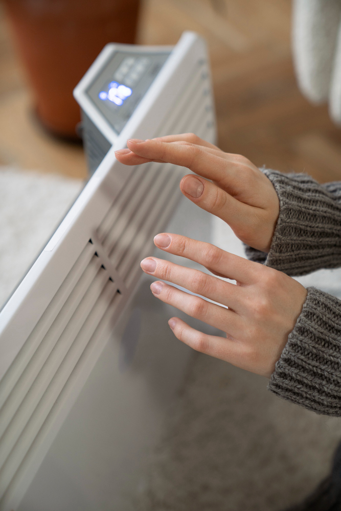 person warming hands by radiator